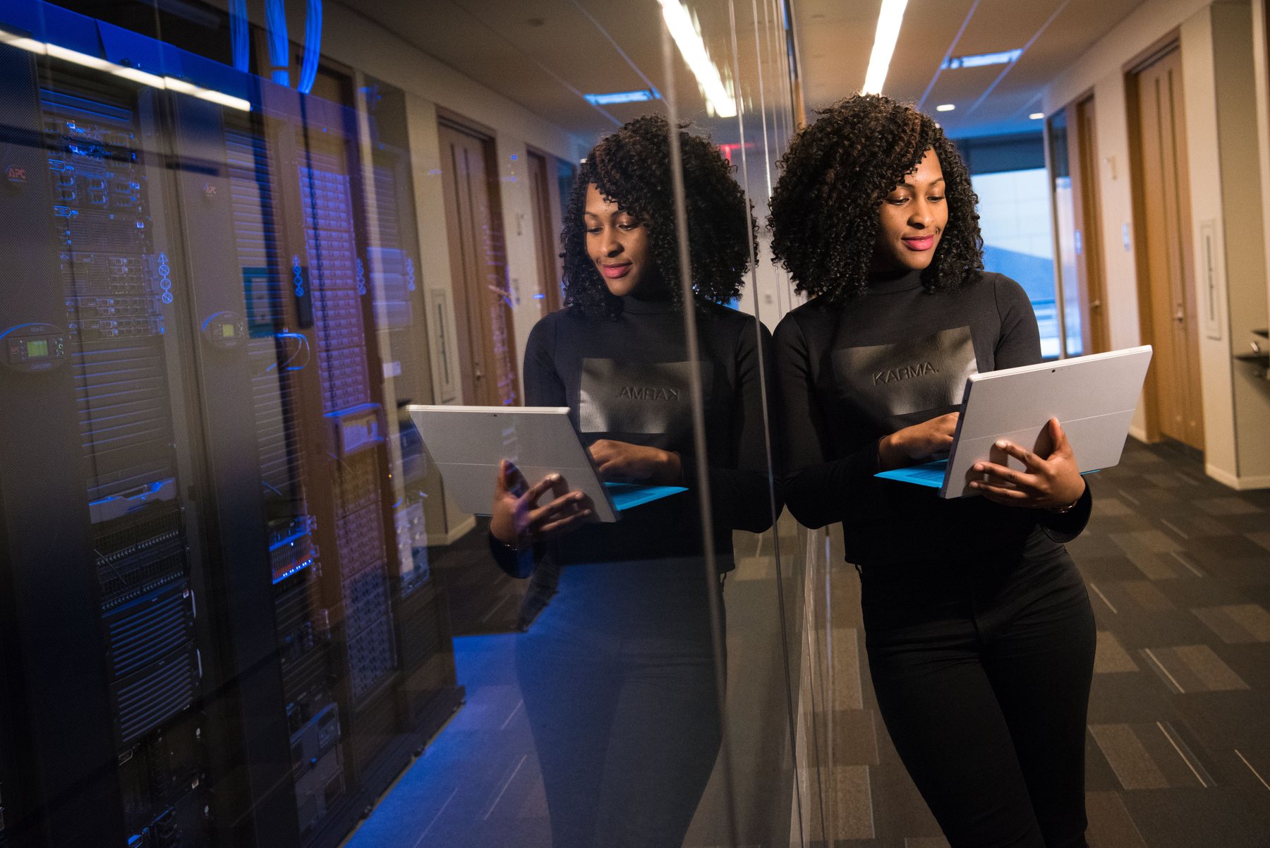 Black technologist working beside server infrastructure